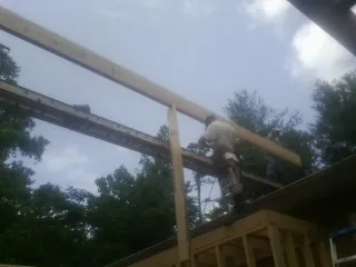 Carpenter setting a ridge beam over a new addition frame — Ice Dam Removal by Roofing Brothers in Seeley Lake